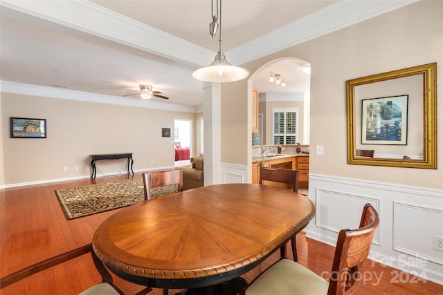 dining area featuring hardwood / wood-style floors, ornamental molding, sink, and ceiling fan