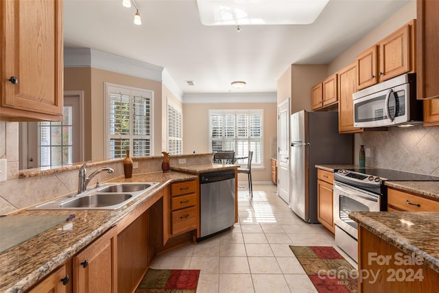 kitchen featuring stainless steel appliances, sink, plenty of natural light, and light tile patterned floors