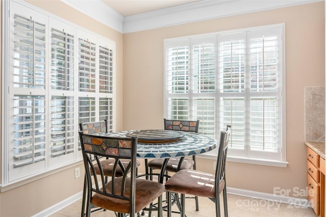 dining room with crown molding, light tile patterned floors, and a wealth of natural light