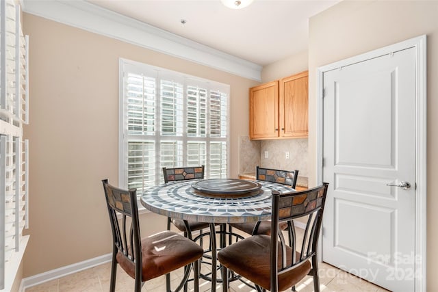 dining space with crown molding and light tile patterned floors