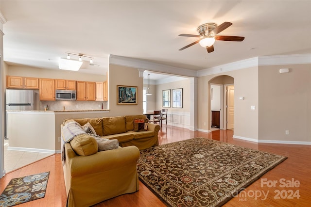 living room with crown molding, light hardwood / wood-style floors, and ceiling fan