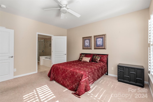 bedroom with ensuite bath, light colored carpet, and ceiling fan