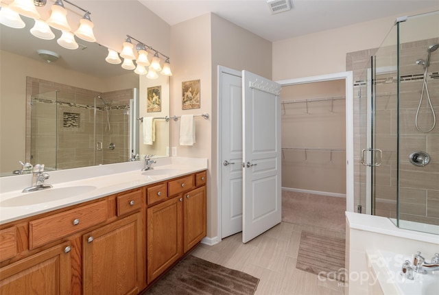 bathroom featuring vanity, a shower with shower door, and tile patterned flooring