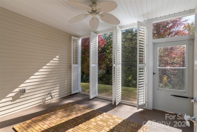 unfurnished sunroom featuring ceiling fan