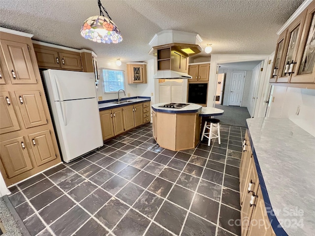 kitchen with sink, a kitchen island, a textured ceiling, hanging light fixtures, and white fridge