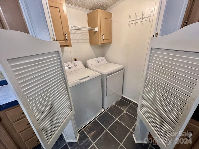 laundry room with cabinets, washer and dryer, a textured ceiling, and ornamental molding