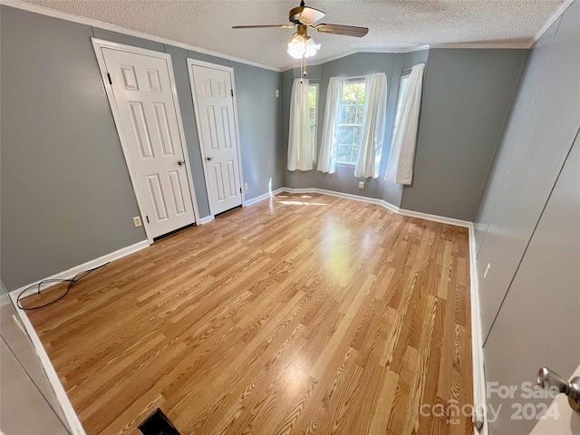 unfurnished bedroom with a textured ceiling, ceiling fan, lofted ceiling, ornamental molding, and light hardwood / wood-style flooring