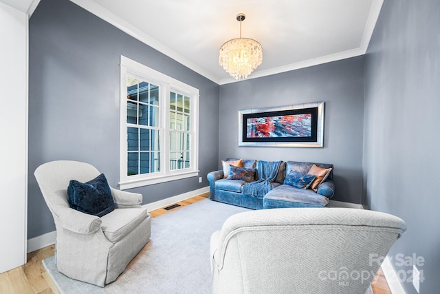 living room featuring crown molding, wood-type flooring, and a chandelier