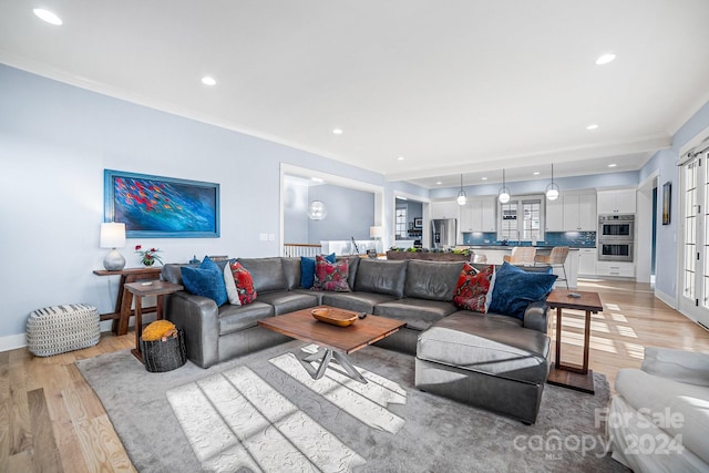 living room featuring ornamental molding and light hardwood / wood-style floors