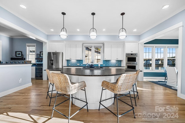 kitchen featuring white cabinetry, appliances with stainless steel finishes, light hardwood / wood-style flooring, and plenty of natural light