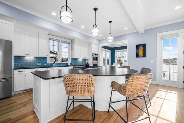 kitchen featuring white cabinetry, light hardwood / wood-style flooring, appliances with stainless steel finishes, and a center island