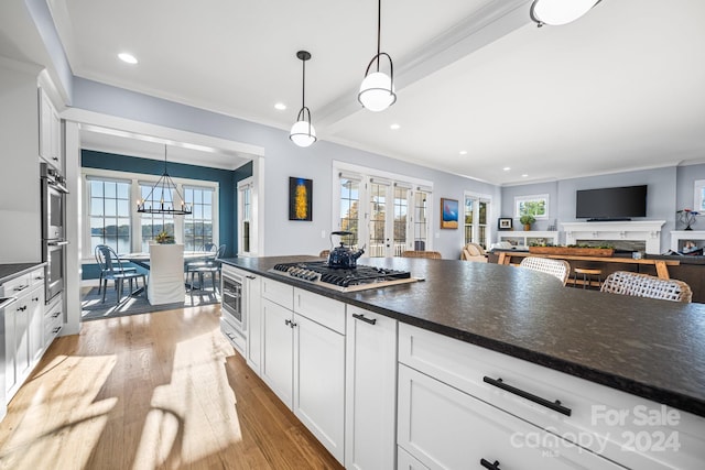 kitchen featuring white cabinetry, pendant lighting, and a healthy amount of sunlight