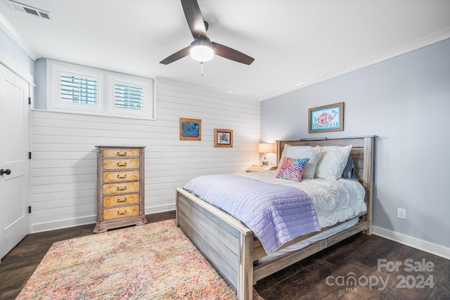 bedroom with dark hardwood / wood-style flooring, crown molding, and ceiling fan