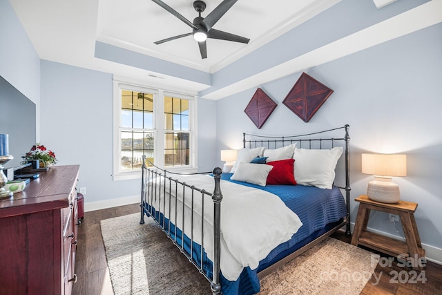 bedroom featuring crown molding, dark wood-type flooring, and ceiling fan