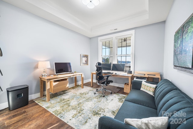 home office with a tray ceiling and wood-type flooring