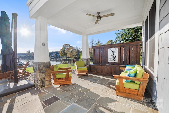 view of patio with a water view and ceiling fan