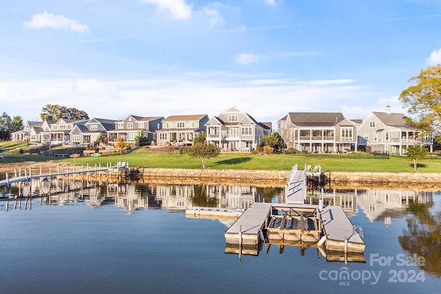 dock area with a water view and a lawn