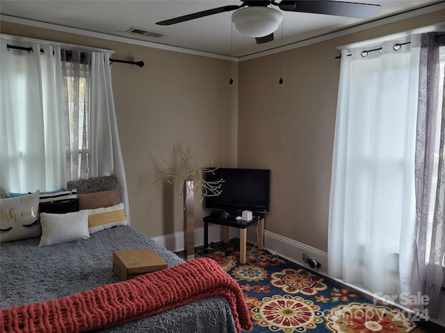 bedroom with ceiling fan and crown molding