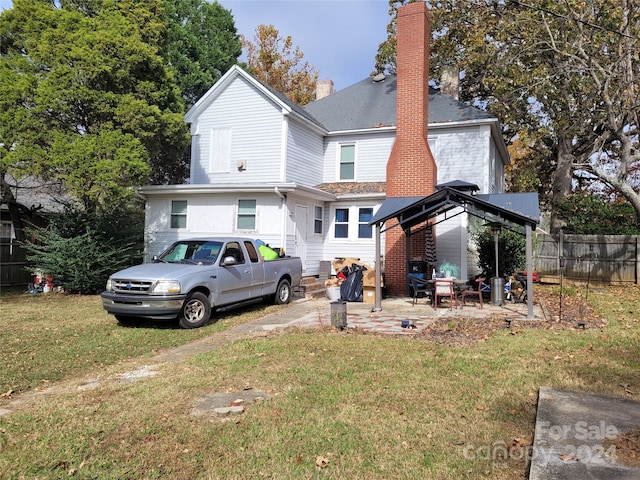 rear view of house with a lawn and a patio area