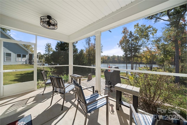 sunroom / solarium featuring a water view