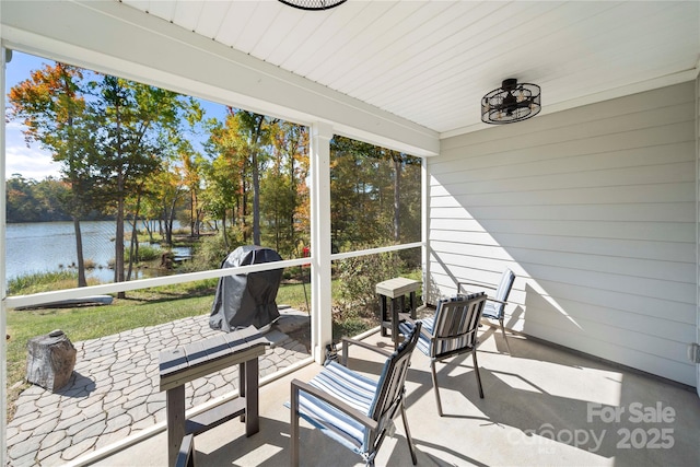 sunroom / solarium featuring a water view