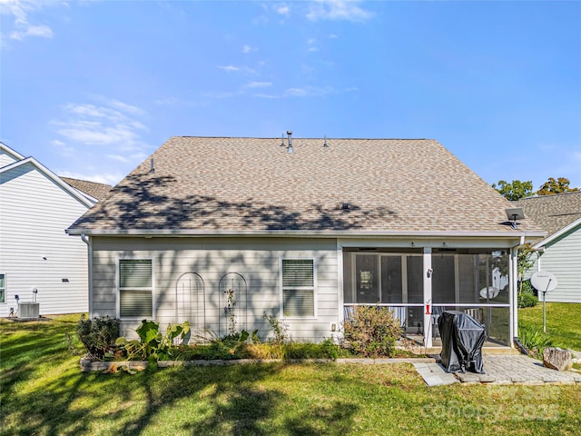 rear view of property with a patio, a sunroom, roof with shingles, cooling unit, and a yard