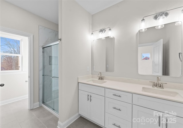 bathroom featuring tile patterned floors, a shower with door, and vanity