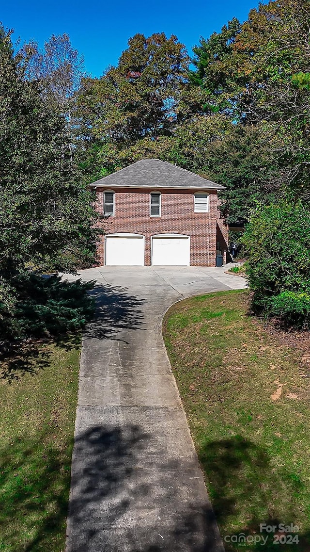 view of side of home featuring a lawn and a garage