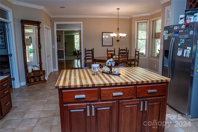 kitchen featuring hanging light fixtures, a kitchen island, stainless steel fridge with ice dispenser, wood counters, and ornamental molding