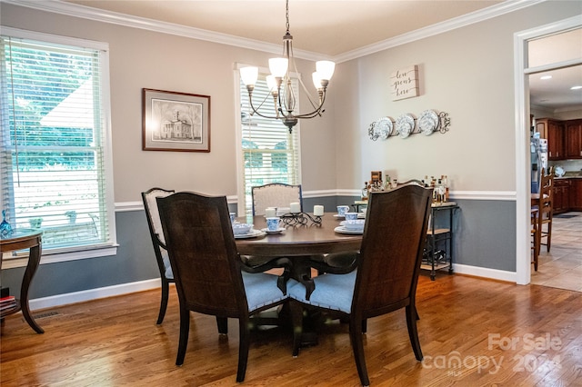 dining room featuring ornamental molding, hardwood / wood-style floors, an inviting chandelier, and plenty of natural light