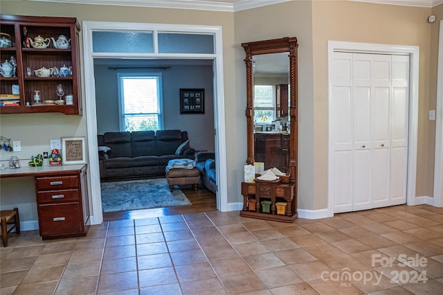 interior space featuring ornamental molding and light tile patterned floors