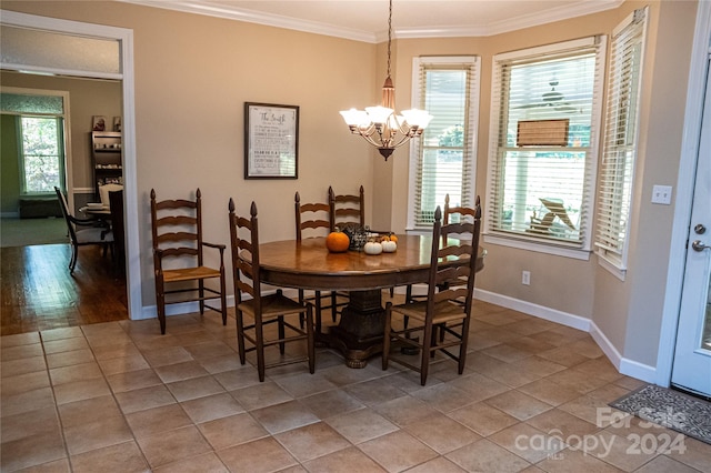 dining area with ornamental molding, wood-type flooring, an inviting chandelier, and plenty of natural light