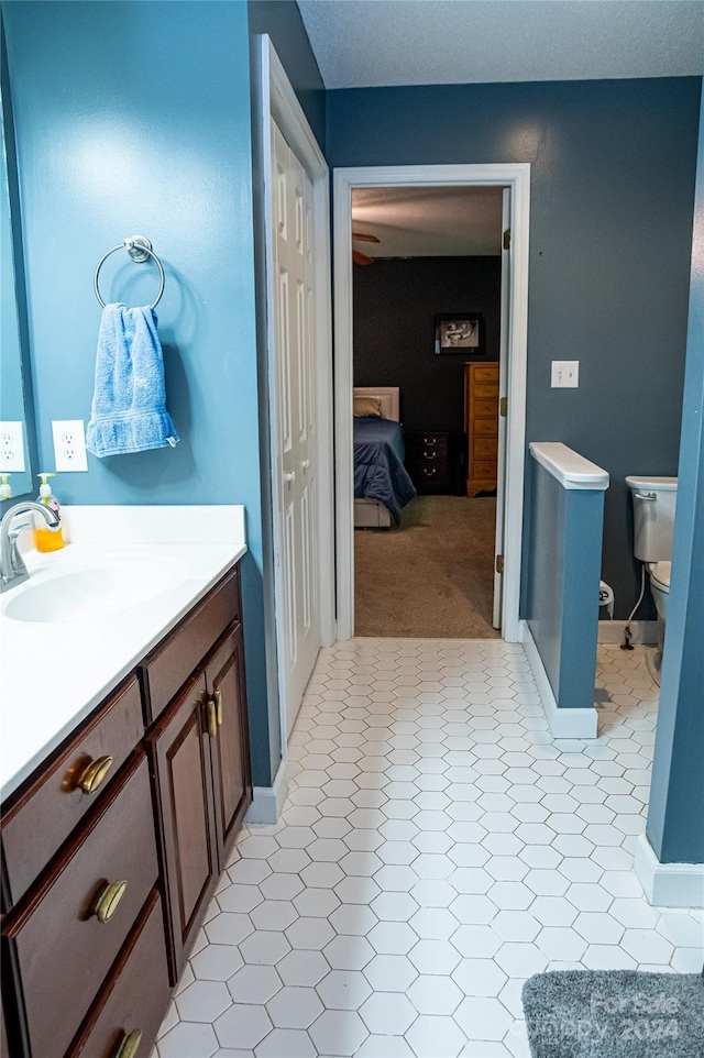 bathroom with vanity, toilet, and tile patterned floors