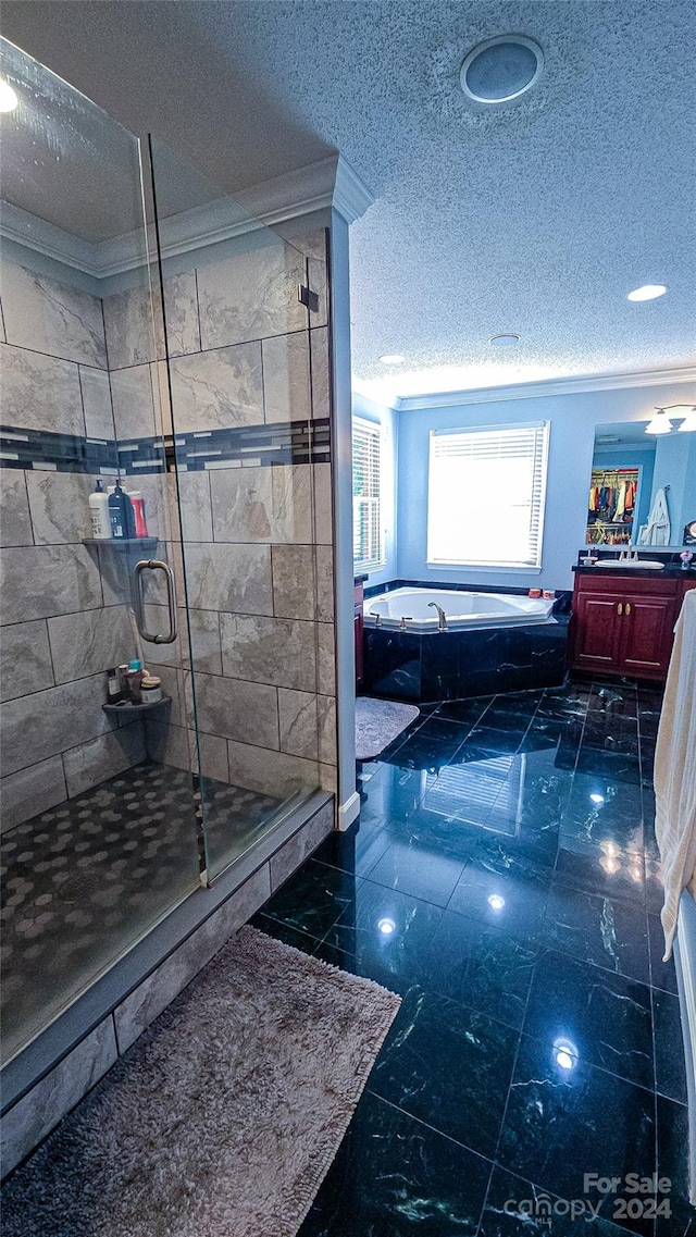 bathroom with vanity, a textured ceiling, ornamental molding, and separate shower and tub