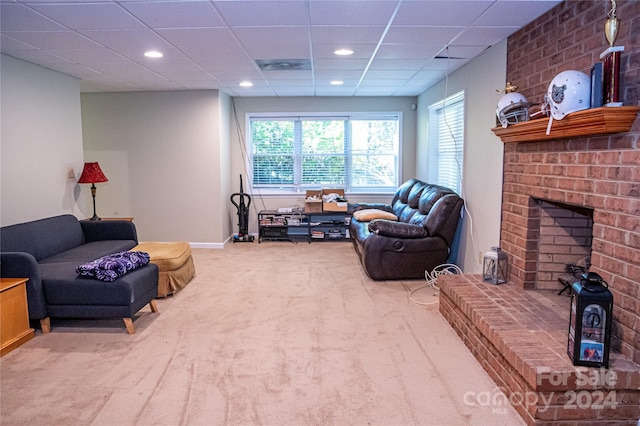 carpeted living room featuring a drop ceiling and a fireplace