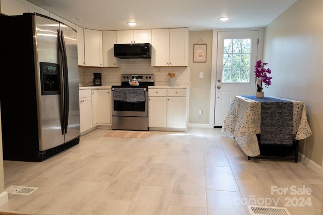 kitchen with tasteful backsplash, white cabinets, and appliances with stainless steel finishes