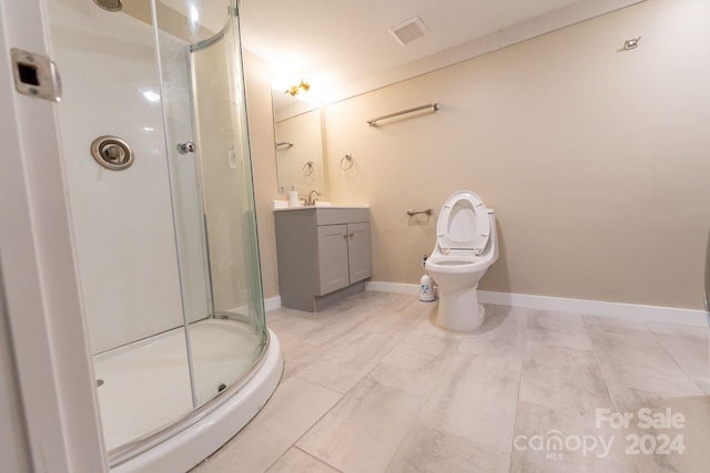 bathroom with a shower with door, vanity, and toilet