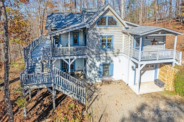 126 Bradley Ascent Ct, Hendersonville, NC 28792 - back of house featuring stairway, a wooden deck, a garage, dirt driveway, and stucco siding