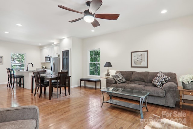 living room featuring light hardwood / wood-style flooring and ceiling fan