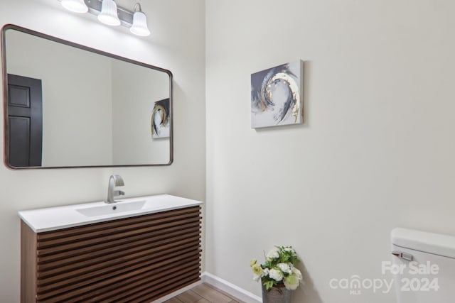 bathroom with vanity, hardwood / wood-style floors, and toilet