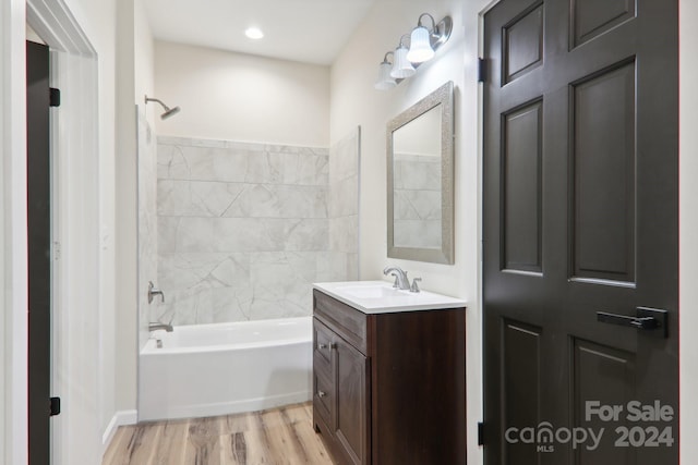 bathroom featuring vanity, tiled shower / bath combo, and hardwood / wood-style floors