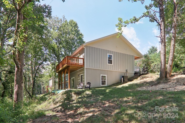 view of side of home featuring central AC and a lawn