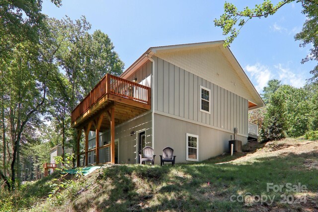 view of side of home featuring a wooden deck and a yard