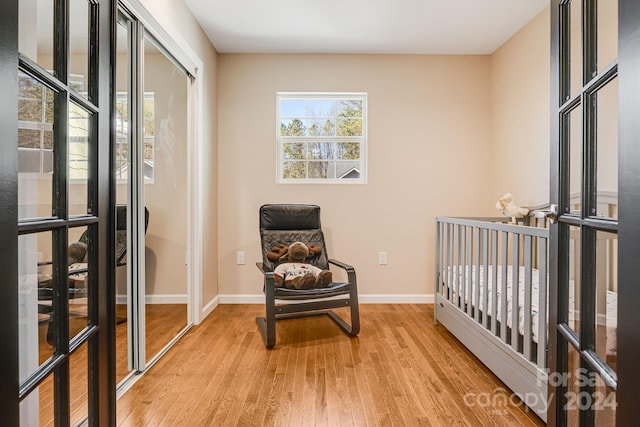 bedroom with french doors, light hardwood / wood-style floors, and a closet