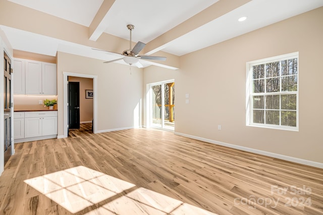 unfurnished living room with beam ceiling, ceiling fan, and light hardwood / wood-style flooring