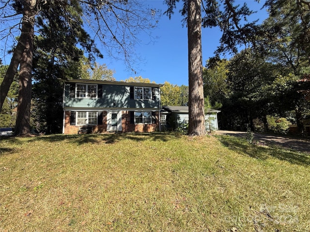 rear view of property featuring a yard and a garage