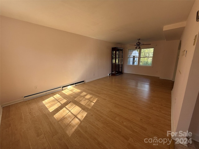 unfurnished room featuring ceiling fan, wood-type flooring, and a baseboard radiator