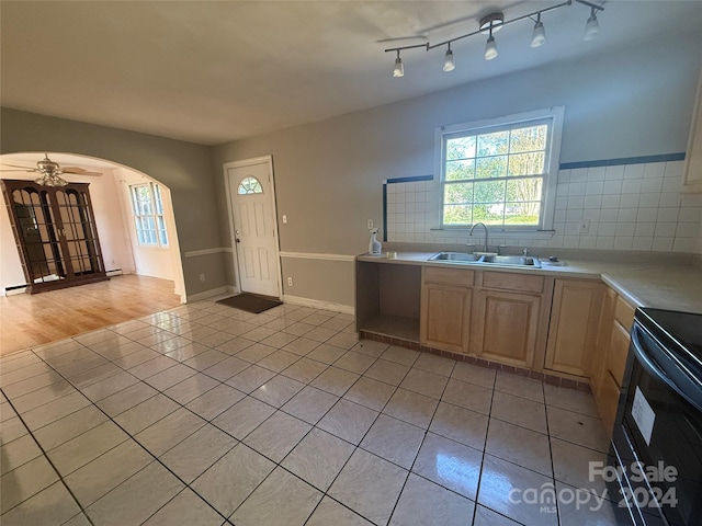 kitchen featuring black range with electric cooktop, sink, light wood-type flooring, ceiling fan, and light brown cabinets