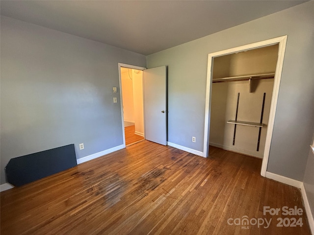 unfurnished bedroom with a closet and wood-type flooring