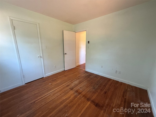 unfurnished bedroom with dark hardwood / wood-style flooring